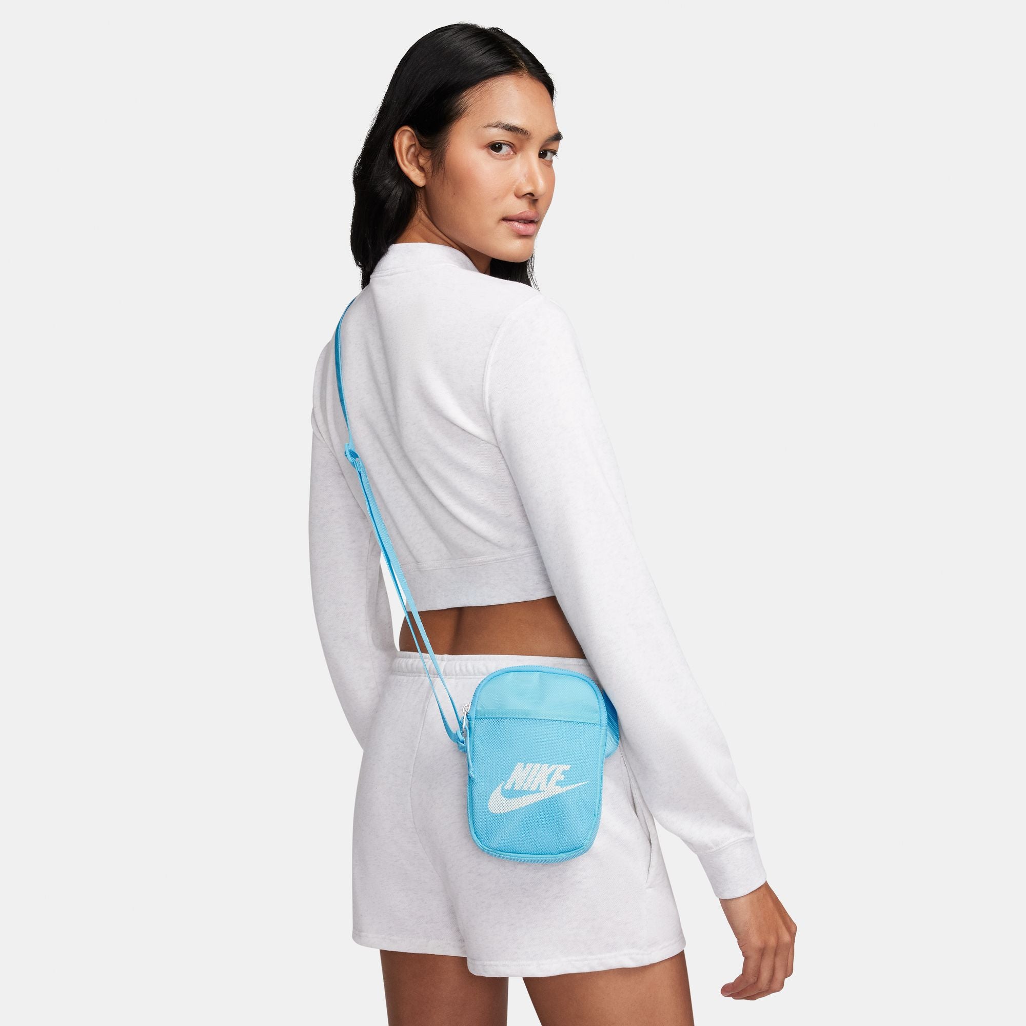 Light blue nike crossbody bag with mesh front pocket and white nike swoosh logo. Free uk shipping over £50