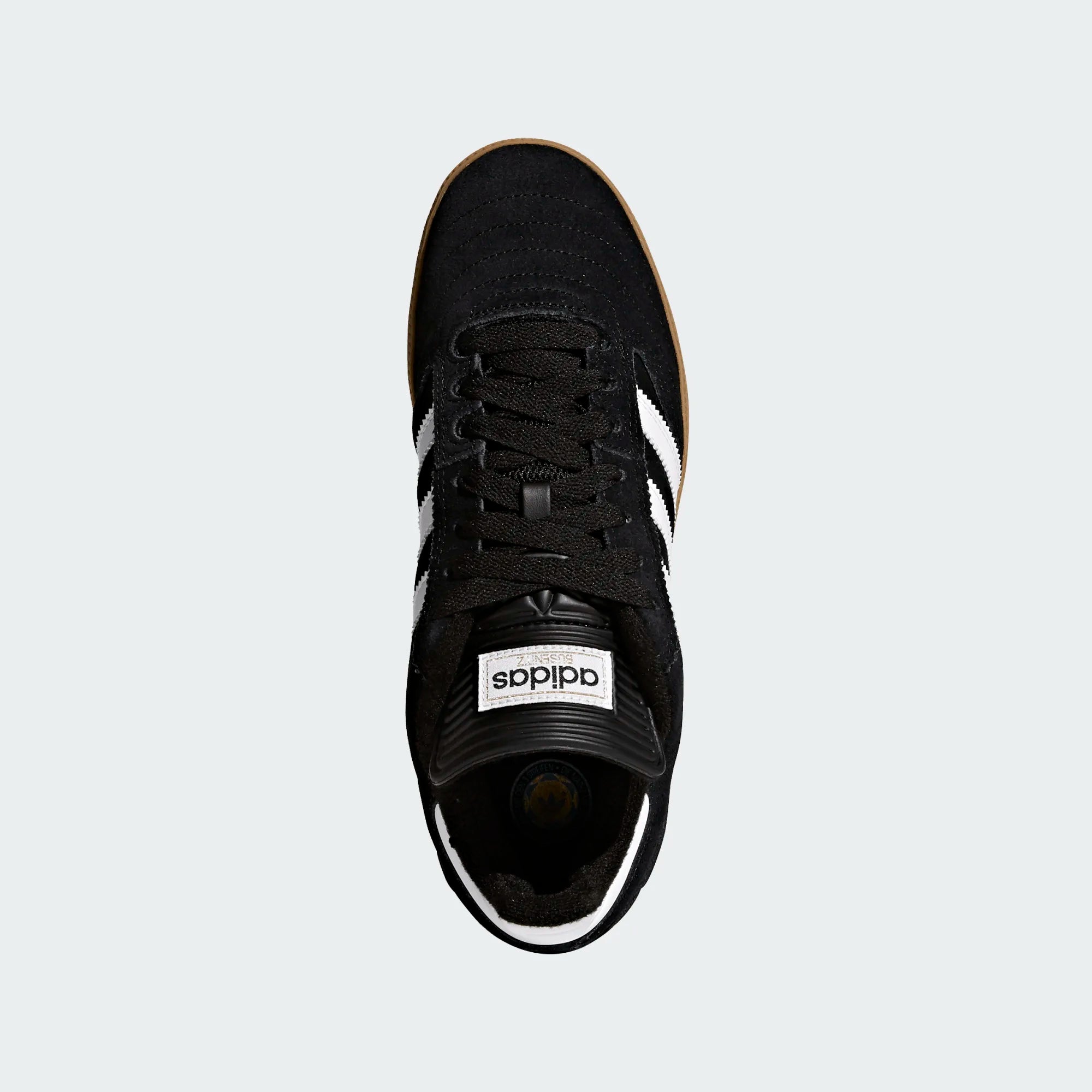 Black Adidas sneaker with white stripes on a light gray background