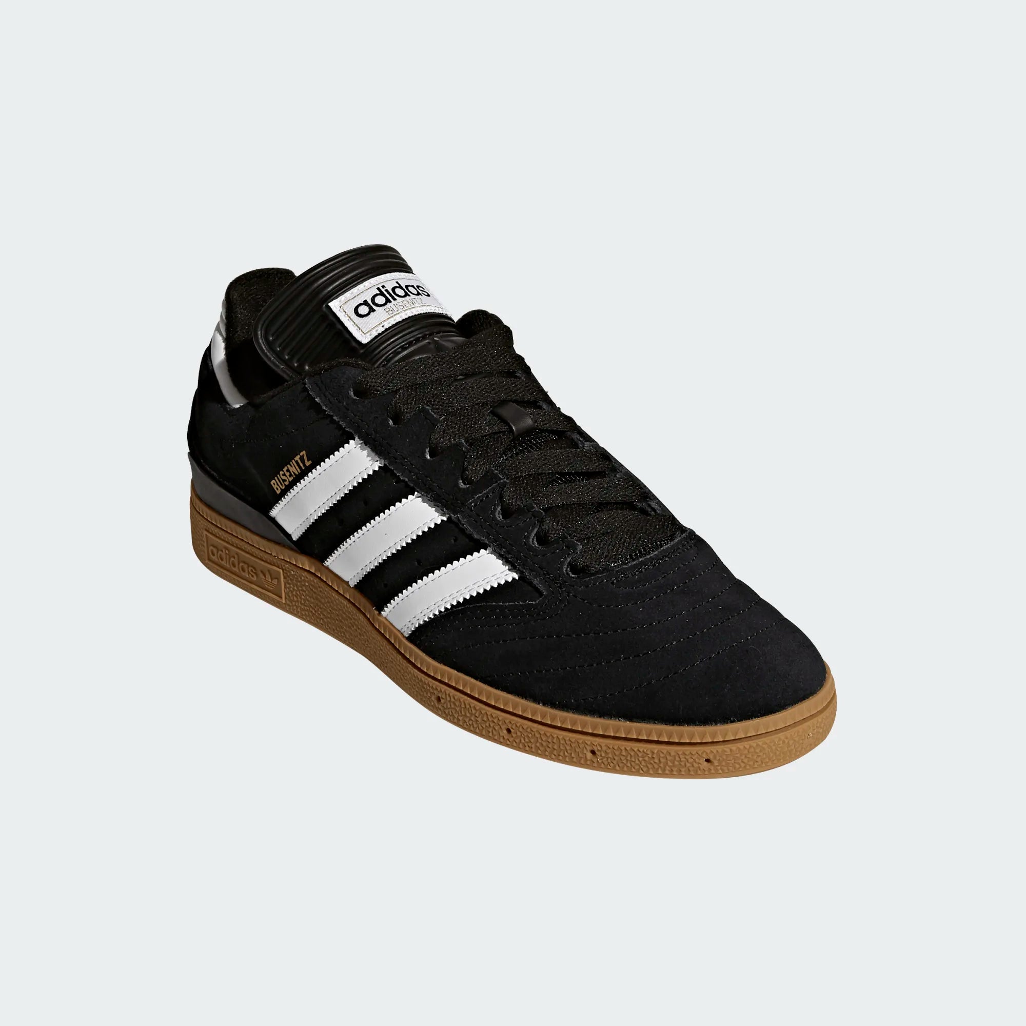Black Adidas sneaker with white stripes on a light gray background