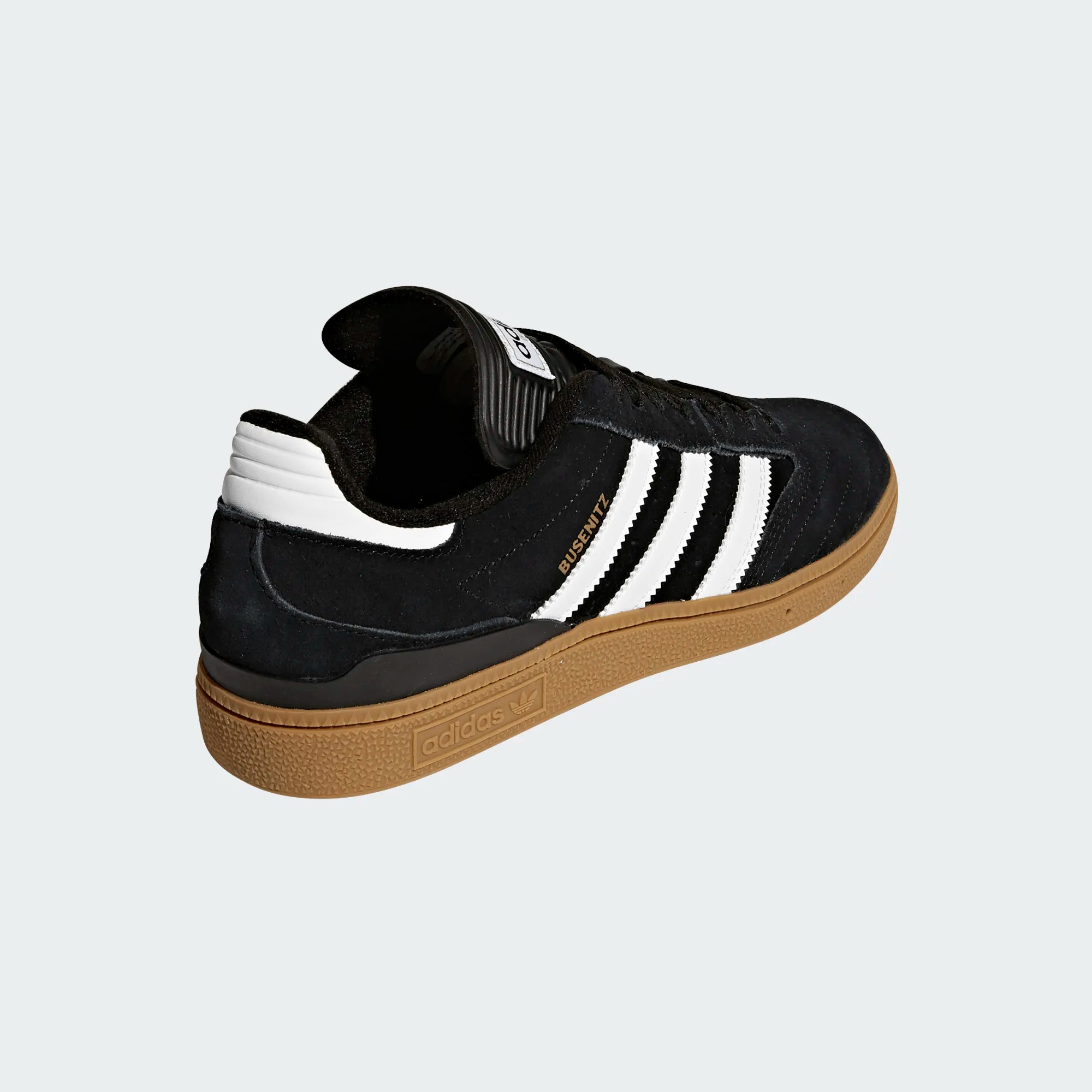 Black Adidas sneaker with white stripes on a light gray background