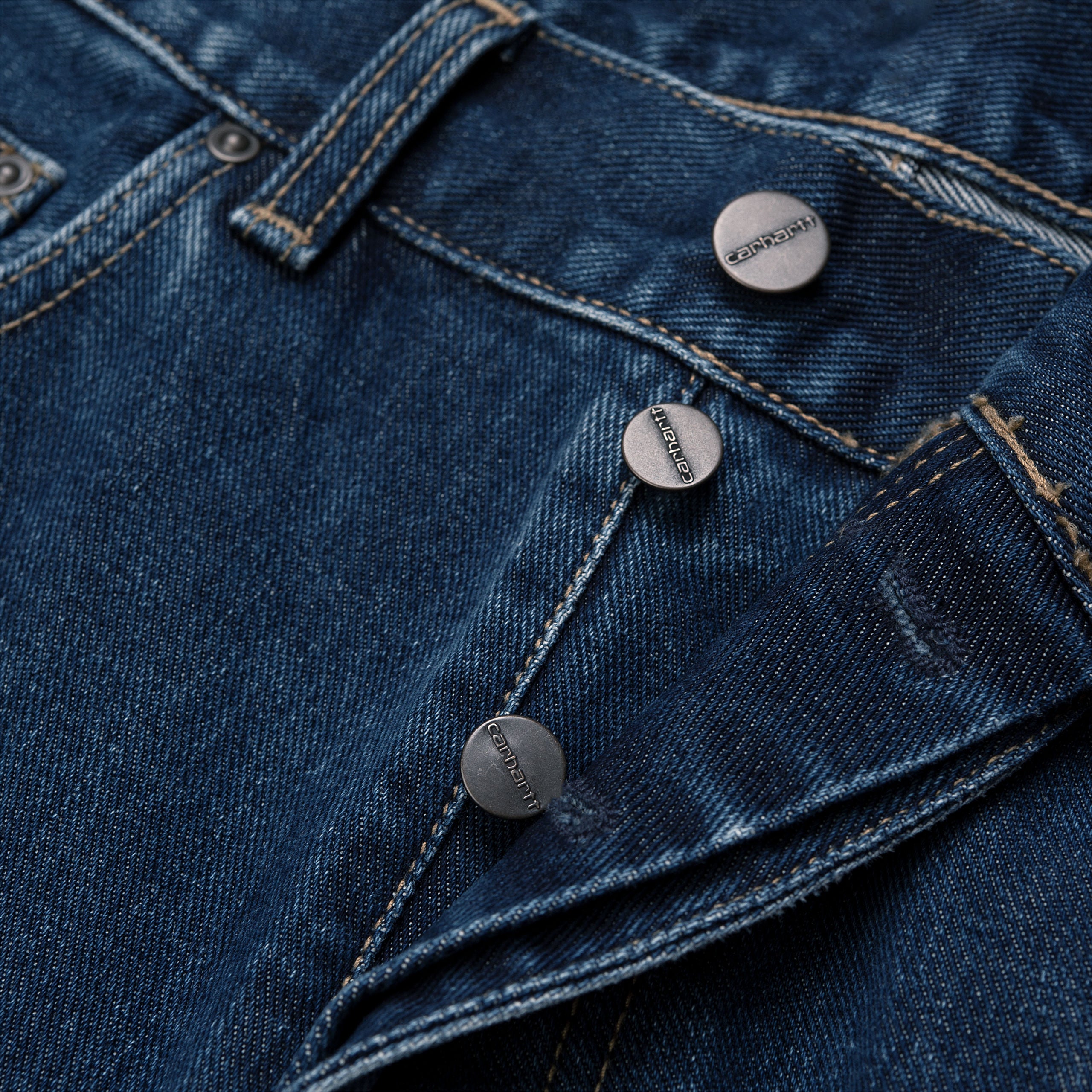 Dark blue denim Carhartt trousers with woven logo on back pocket. Free UK shipping on orders over £50.