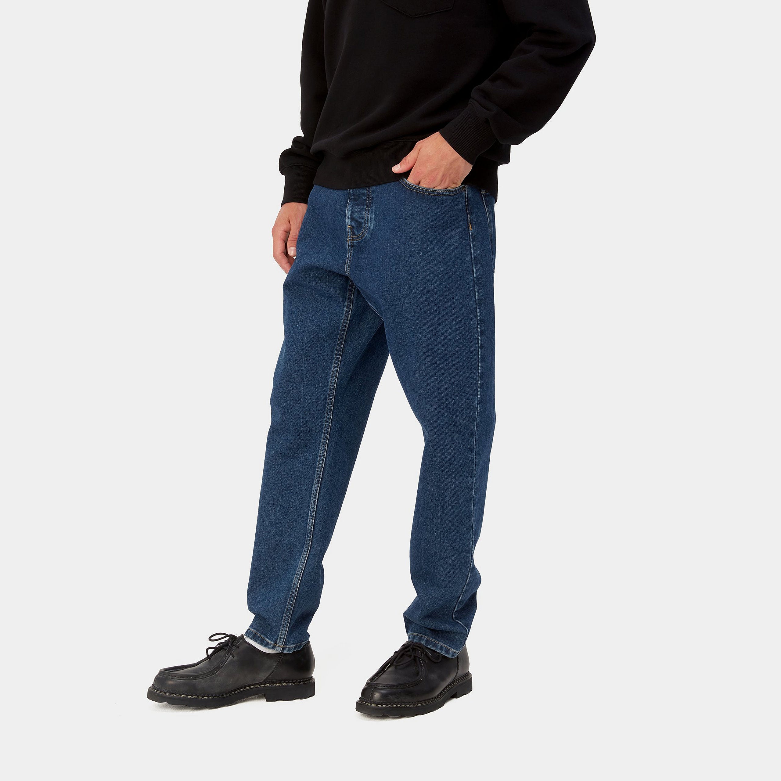 Dark blue denim Carhartt trousers with woven logo on back pocket. Free UK shipping on orders over £50.
