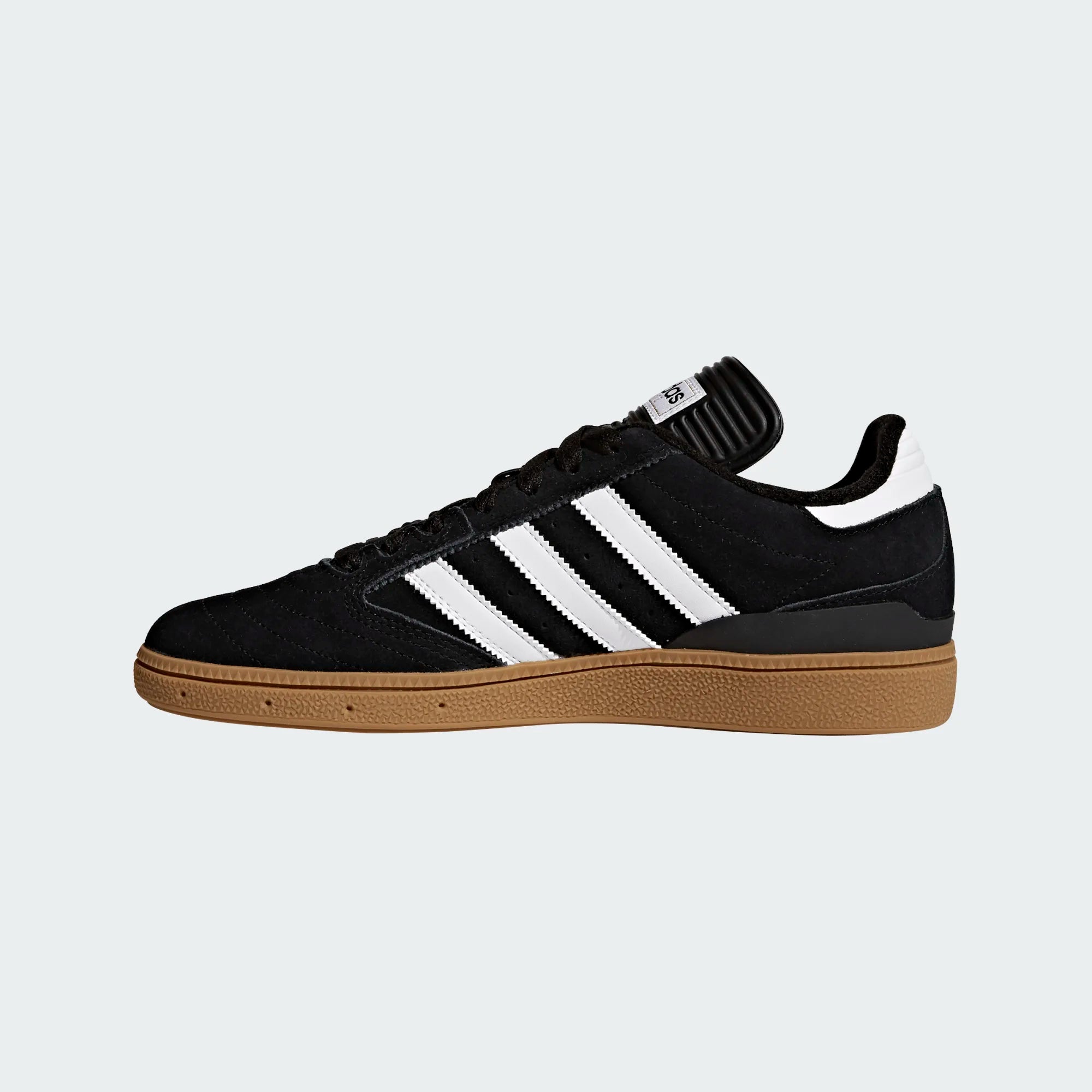Black Adidas sneaker with white stripes on a light gray background